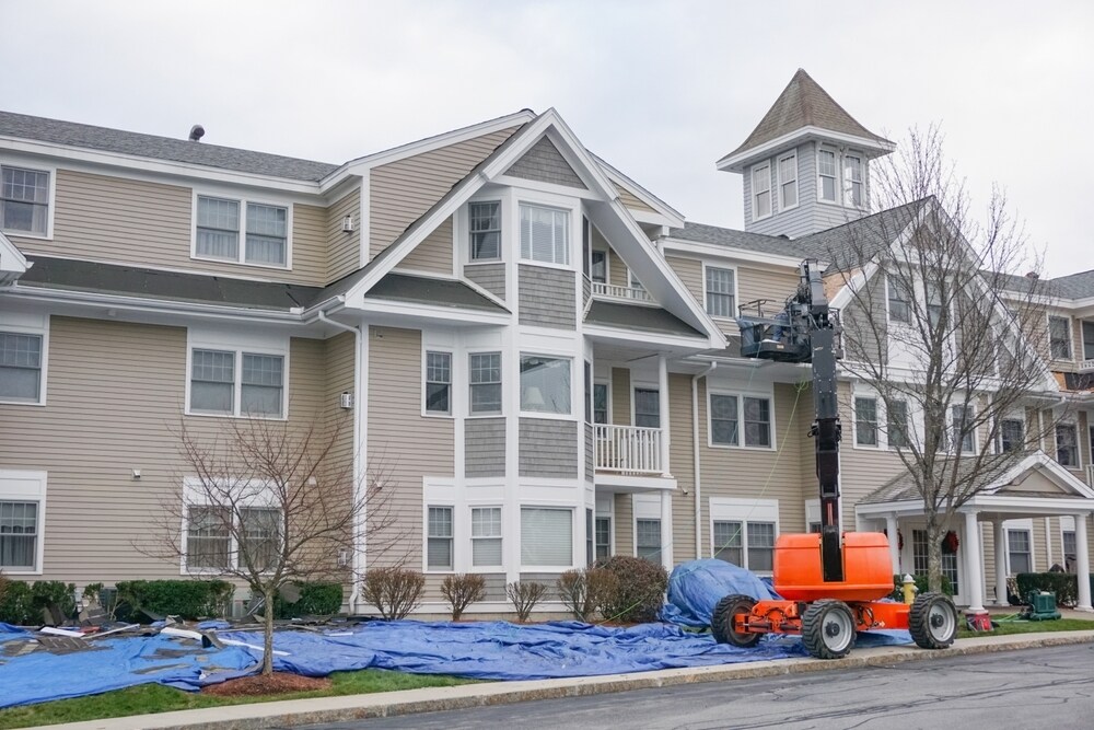 roof repair of apartment building, construction site with crane     