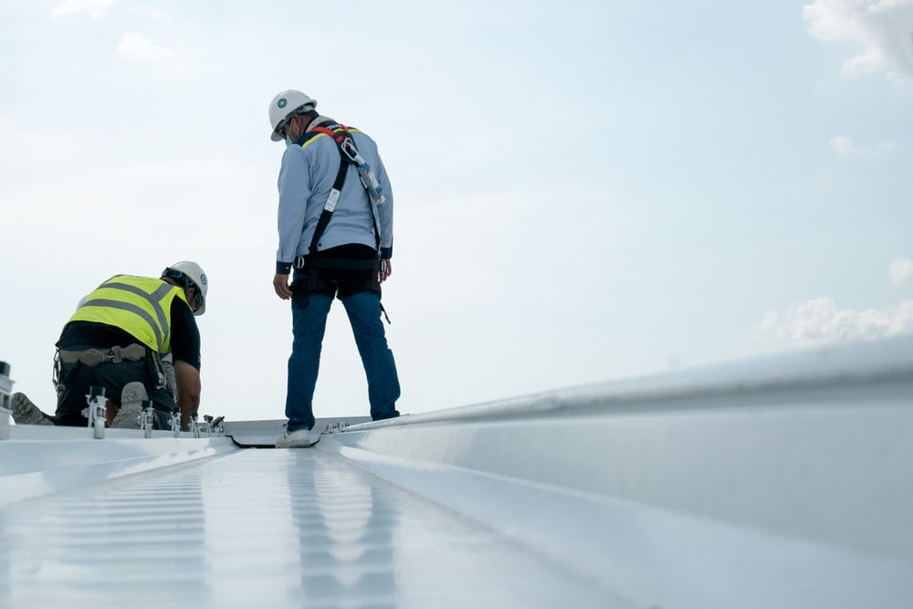 Two engineers inspect complex industrial roof.