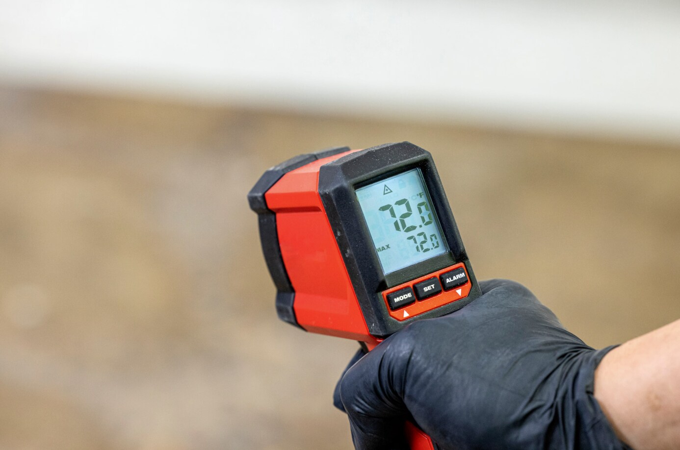 A Contractor using a laser temperature gun