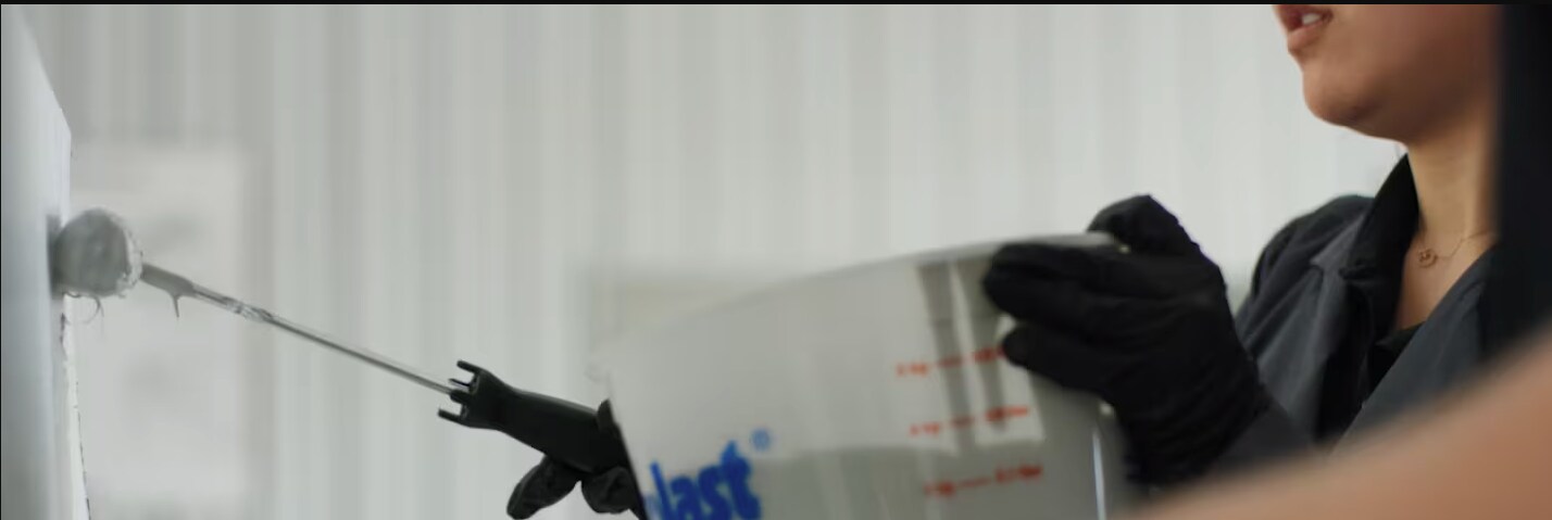 Siplast worker rolling a liquid applied membrane onto a surface
